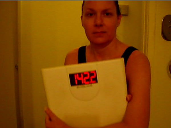 Christy holding scale showing Weight of 142 pounds 10-14-2015